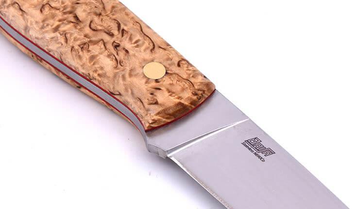 Brisa Trapper 95 con mango de madera estabilizada de abedul rizado y hoja flat de acero N690Co con funda bushcraft con pedernal